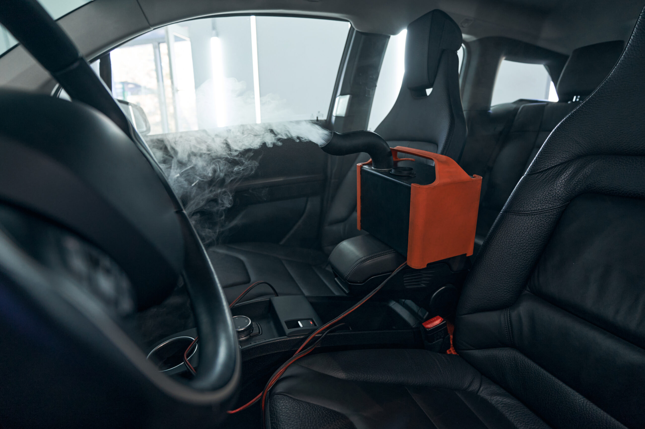 Ozone odor treatment machine running inside a car during mobile interior detailing